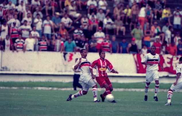 Em 3 de agosto de 2003, no Arruda, o Santa Cruz, comandado por Péricles Chamusca, venceu o Náutico por 2 a 0. O zagueiro Bebeto abriu o placar aos 20 minutos do 1º tempo. Aos 7 do 2º tempo, Adriano teve a chance de empatar o jogo, numa cobrança de pênalti. João Carlos defendeu. Aos 34, Roberto fez o segundo do Santa Cruz. O resultado derrubou o técnico Heriberto da Cunha, do Náutico.