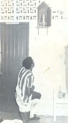 1974 - O Santa Cruz poderia igualar o feito do Náutico e conquistar o Hexacampeonato Estadual. Mas o Timbu se sobressaiu. Após evitar o título coral no segundo turno, a decisão só precisou de dois jogos, na melhor de três. Duas vitórias com o mesmo placar de 1 a 0 deram ao Náutico o 14° título, e a manutenção da maior sequência de conquistas no futebol pernambucano. Na foto, Juca Show no vestiário agradece à Virgem pela conquista do título.