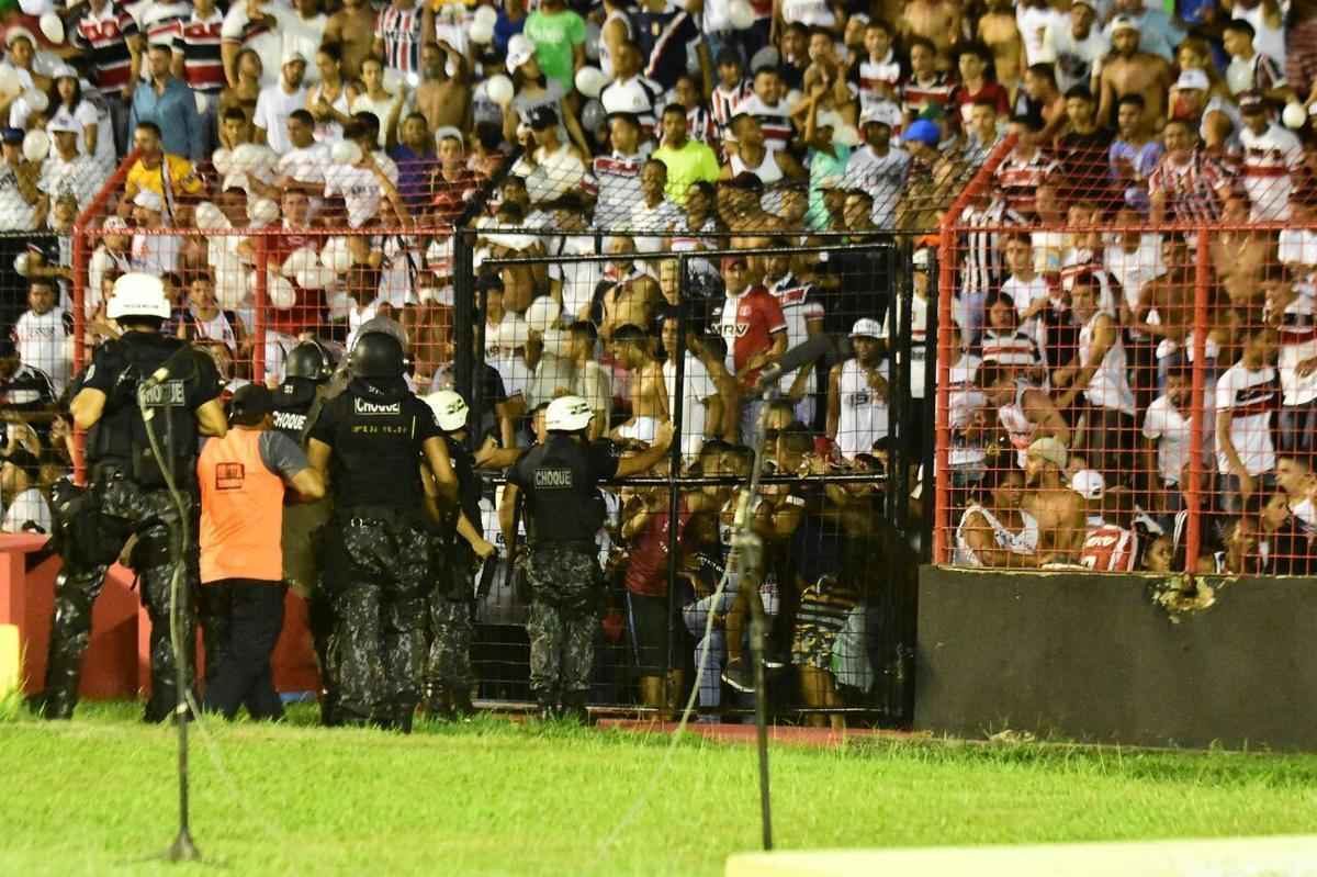 O gramado da Ilha do Retiro virou palco de cenas lamentveis ao fim do primeiro tempo do Clssico das Multides. Aps policiais militares adentrarem na torcida do Santa Cruz para apagar um sinalizador, artefato proibido nos estdios, a confuso tomou conta do local. Alguns torcedores caram pelas arquibancadas e outris entraram em confronto com a PM. Muita gente ficou ferida e foi atendida no gramado, atrs do gol. Os mais graves foram removidos por ambulncias para a UPA da Abdias
