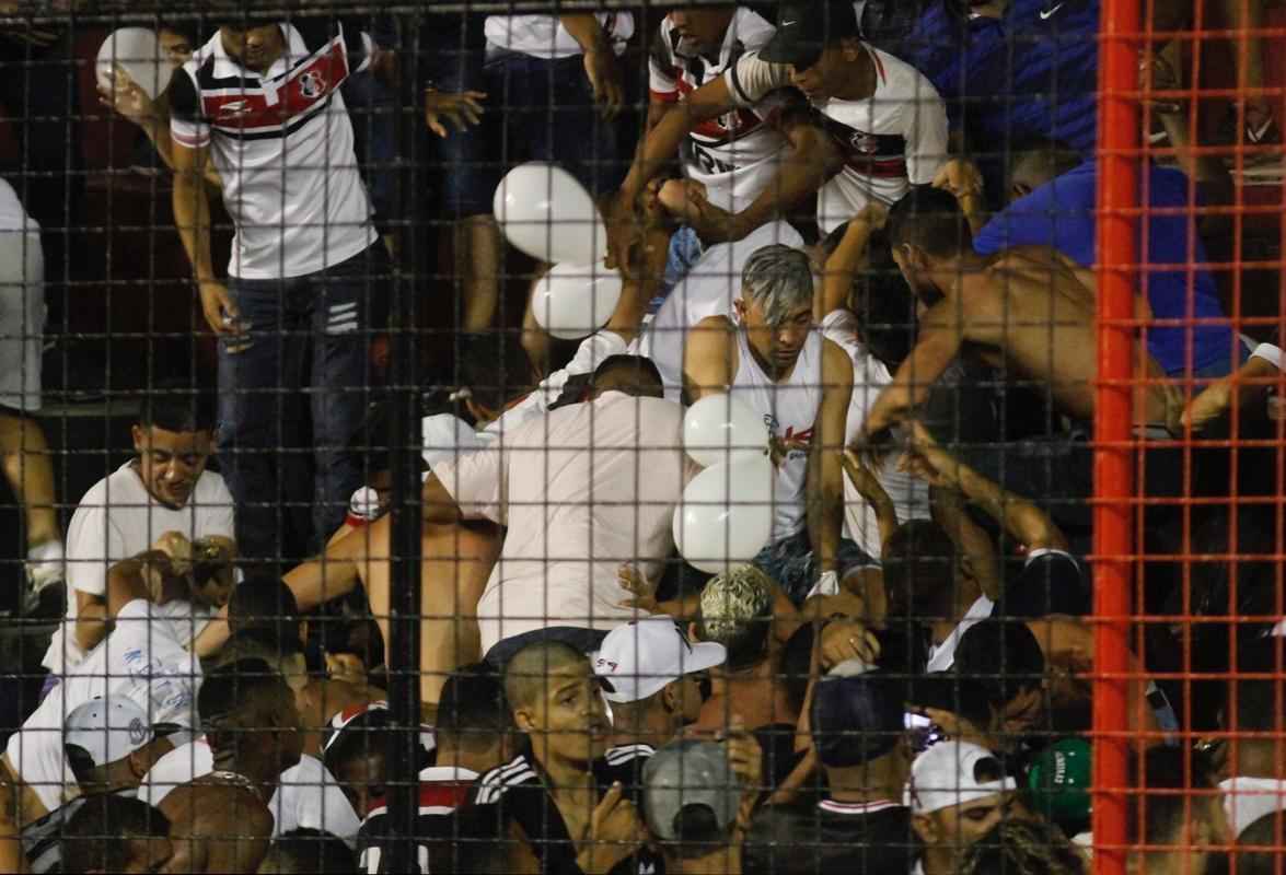 O gramado da Ilha do Retiro virou palco de cenas lamentveis ao fim do primeiro tempo do Clssico das Multides. Aps policiais militares adentrarem na torcida do Santa Cruz para apagar um sinalizador, artefato proibido nos estdios, a confuso tomou conta do local. Alguns torcedores caram pelas arquibancadas e outris entraram em confronto com a PM. Muita gente ficou ferida e foi atendida no gramado, atrs do gol. Os mais graves foram removidos por ambulncias para a UPA da Abdias