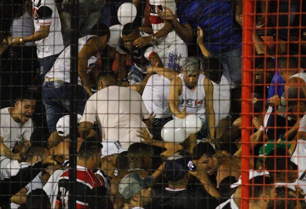 O gramado da Ilha do Retiro virou palco de cenas lamentveis ao fim do primeiro tempo do Clssico das Multides. Aps policiais militares adentrarem na torcida do Santa Cruz para apagar um sinalizador, artefato proibido nos estdios, a confuso tomou conta do local. Alguns torcedores caram pelas arquibancadas e outris entraram em confronto com a PM. Muita gente ficou ferida e foi atendida no gramado, atrs do gol. Os mais graves foram removidos por ambulncias para a UPA da Abdias