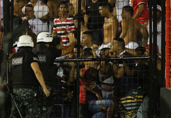 O gramado da Ilha do Retiro virou palco de cenas lamentveis ao fim do primeiro tempo do Clssico das Multides. Aps policiais militares adentrarem na torcida do Santa Cruz para apagar um sinalizador, artefato proibido nos estdios, a confuso tomou conta do local. Alguns torcedores caram pelas arquibancadas e outris entraram em confronto com a PM. Muita gente ficou ferida e foi atendida no gramado, atrs do gol. Os mais graves foram removidos por ambulncias para a UPA da Abdias