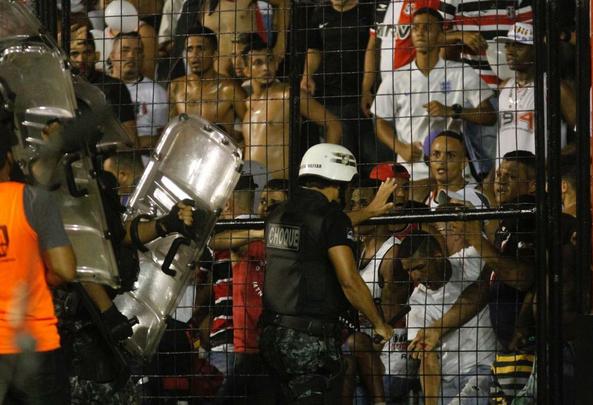 O gramado da Ilha do Retiro virou palco de cenas lamentveis ao fim do primeiro tempo do Clssico das Multides. Aps policiais militares adentrarem na torcida do Santa Cruz para apagar um sinalizador, artefato proibido nos estdios, a confuso tomou conta do local. Alguns torcedores caram pelas arquibancadas e outris entraram em confronto com a PM. Muita gente ficou ferida e foi atendida no gramado, atrs do gol. Os mais graves foram removidos por ambulncias para a UPA da Abdias