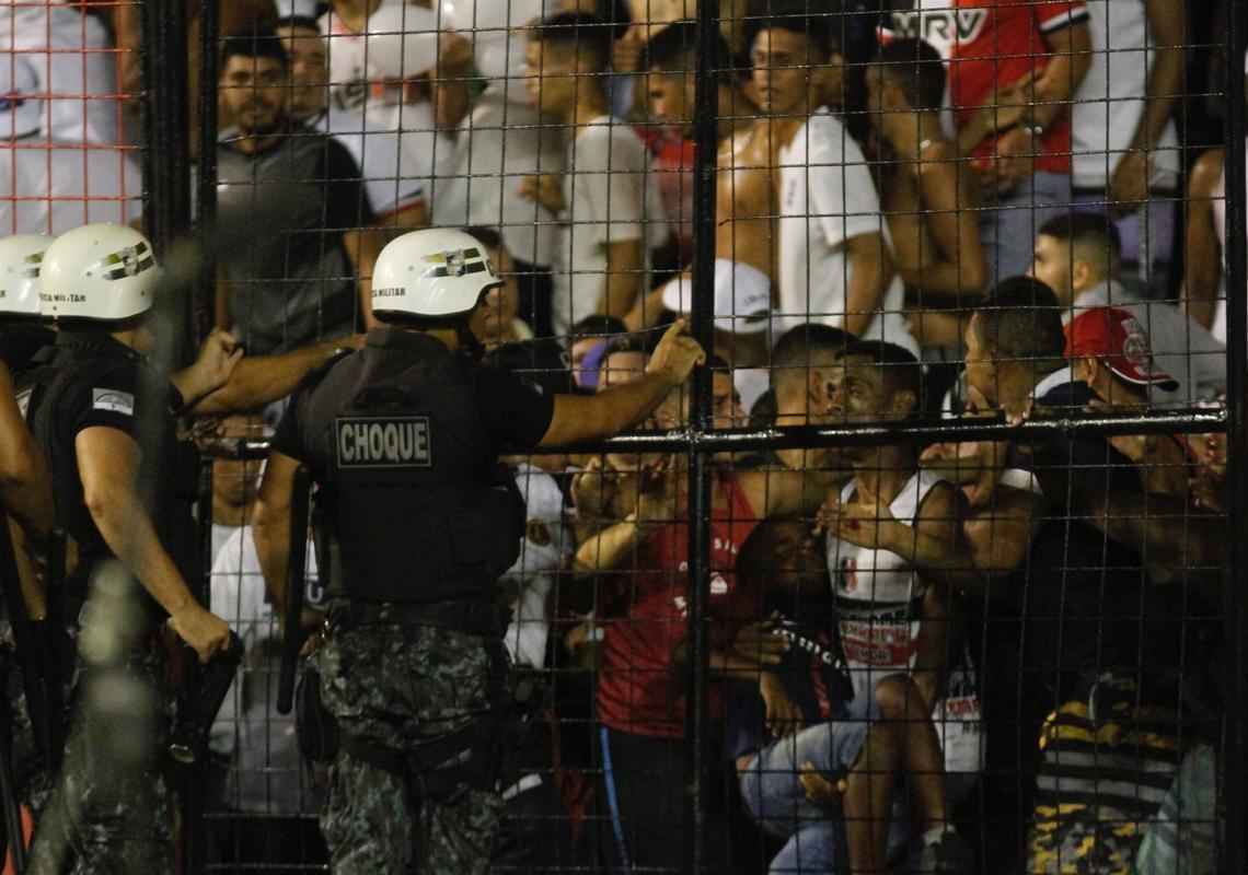 O gramado da Ilha do Retiro virou palco de cenas lamentveis ao fim do primeiro tempo do Clssico das Multides. Aps policiais militares adentrarem na torcida do Santa Cruz para apagar um sinalizador, artefato proibido nos estdios, a confuso tomou conta do local. Alguns torcedores caram pelas arquibancadas e outris entraram em confronto com a PM. Muita gente ficou ferida e foi atendida no gramado, atrs do gol. Os mais graves foram removidos por ambulncias para a UPA da Abdias