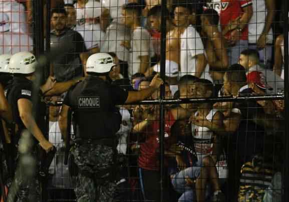 O gramado da Ilha do Retiro virou palco de cenas lamentveis ao fim do primeiro tempo do Clssico das Multides. Aps policiais militares adentrarem na torcida do Santa Cruz para apagar um sinalizador, artefato proibido nos estdios, a confuso tomou conta do local. Alguns torcedores caram pelas arquibancadas e outris entraram em confronto com a PM. Muita gente ficou ferida e foi atendida no gramado, atrs do gol. Os mais graves foram removidos por ambulncias para a UPA da Abdias