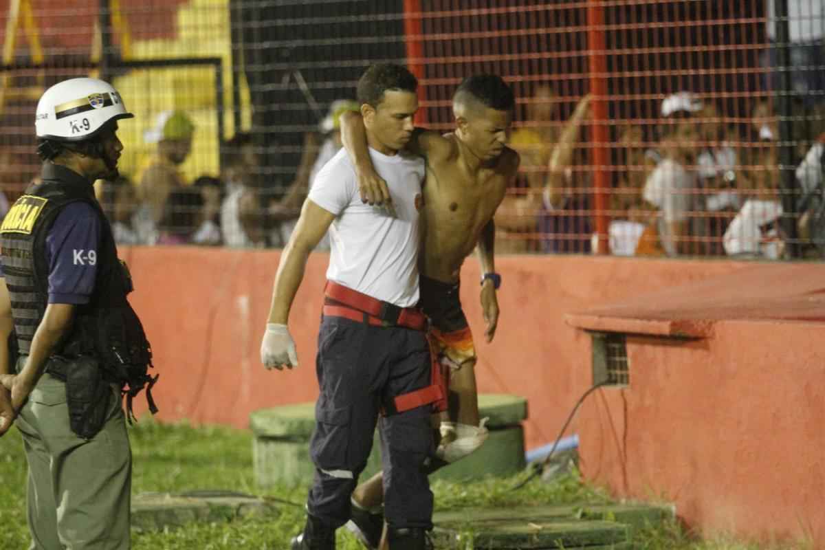 O gramado da Ilha do Retiro virou palco de cenas lamentveis ao fim do primeiro tempo do Clssico das Multides. Aps policiais militares adentrarem na torcida do Santa Cruz para apagar um sinalizador, artefato proibido nos estdios, a confuso tomou conta do local. Alguns torcedores caram pelas arquibancadas e outris entraram em confronto com a PM. Muita gente ficou ferida e foi atendida no gramado, atrs do gol. Os mais graves foram removidos por ambulncias para a UPA da Abdias