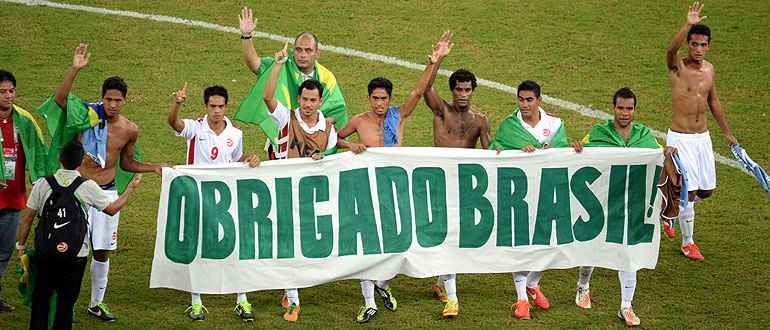 Jogadores da seleção taitiana agradecem aos brasileiros com faixa dentro do gramado: 